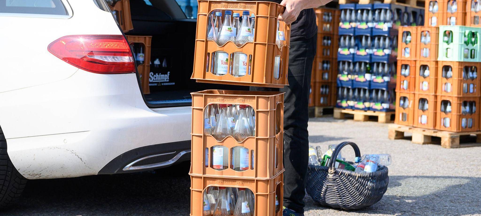 Ein Mann verlädt Mineralwasserkästen